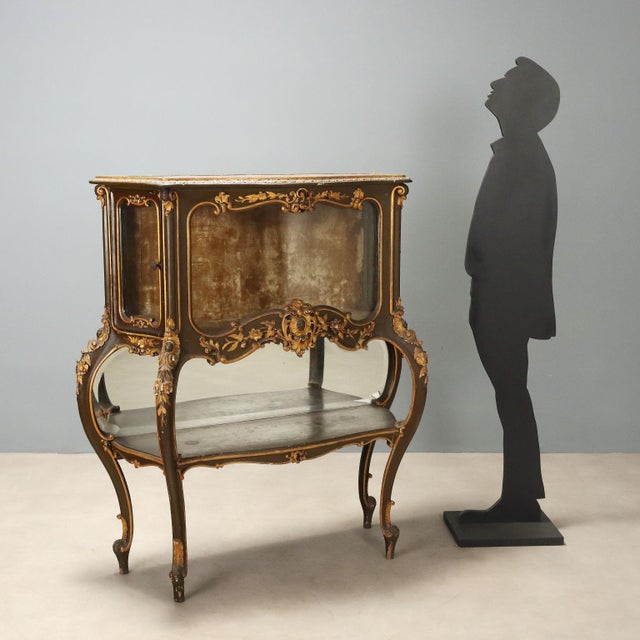 Showcase in Barocchetto style, crafted from carved, lacquered, and gilded wood, originating from late 19th century Italy....