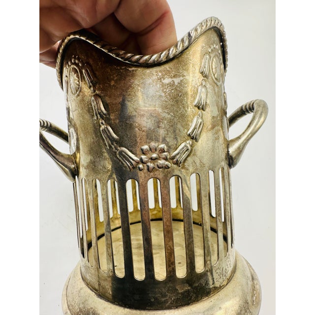 This is a vintage silver or silver-plated holder, possibly used as a wine holder or for decorative purposes. The design...