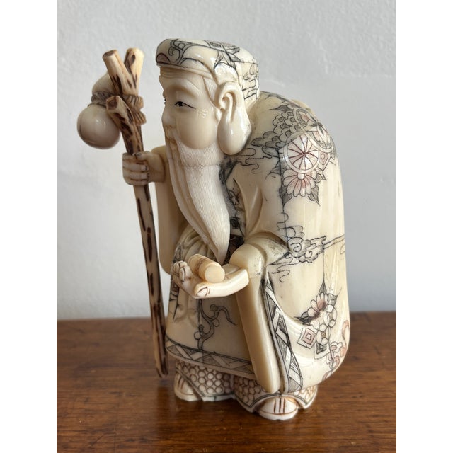 Antique Chinese carved immortal figurine of Shou Lao, who represents longevity, holding his staff topped with a gourd in...