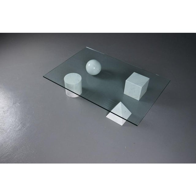 Coffee table made of a glass plate and four marble elements in the form of a pyramied, ball, cube and cylinder designed by...