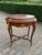 This refined early 1900s French Louis XVI–style side table combines richly toned mahogany with decorative gilt-bronze...