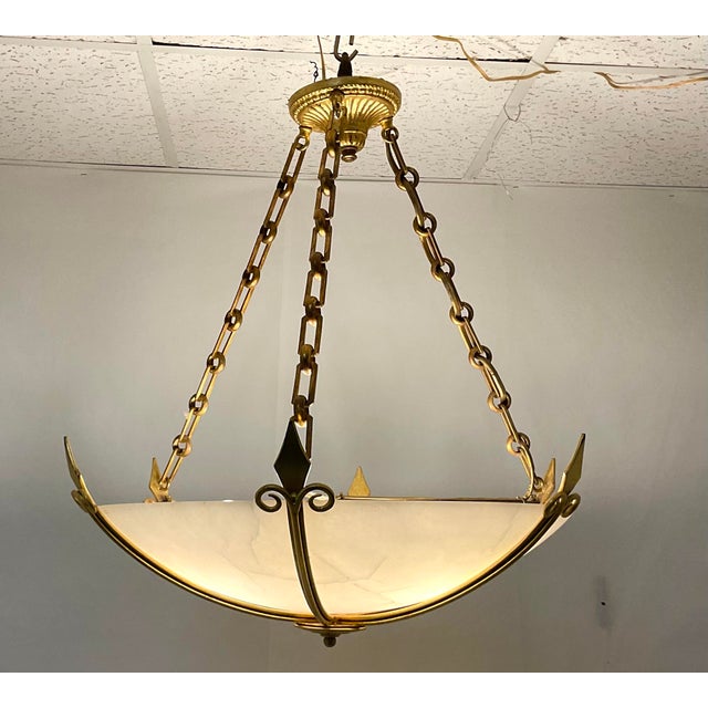 This striking chandelier combines timeless elegance with refined craftsmanship. The hand-carved alabaster bowl shade emits...