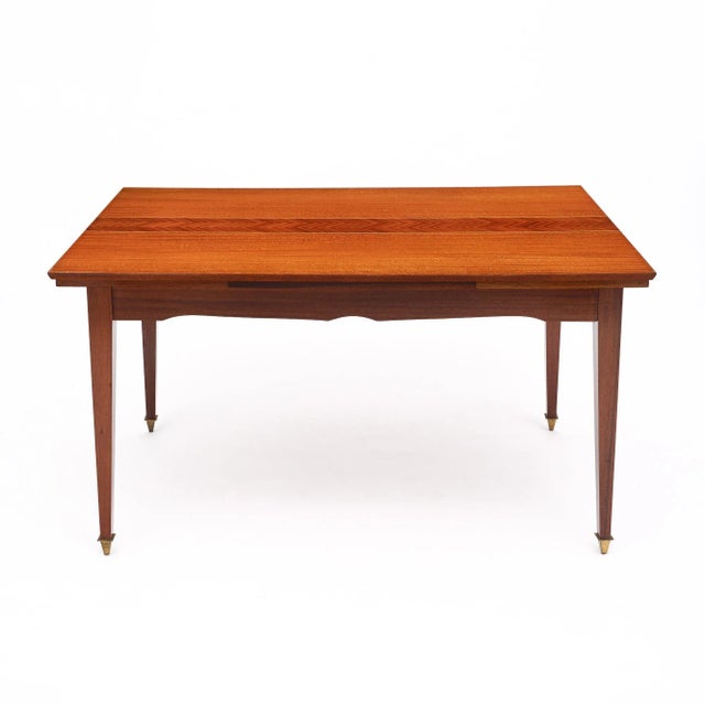 Mid-century dining table from France made of rosewood. This piece features a beautiful rosewood veneer with a stripe of...