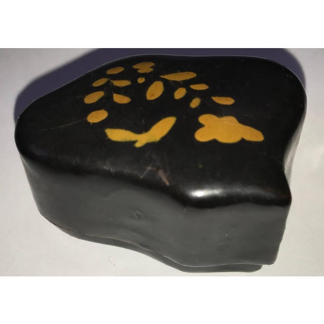 Unusual curves make this black lacquer snuff box unique. Tiny flowers decorate the top. This is a nice collectible to add...