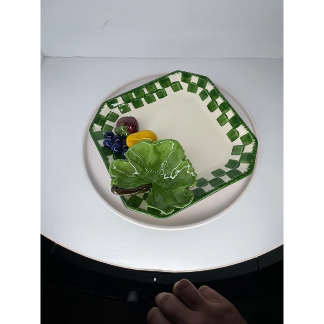 Cali-signed green checker rimmed serving dish with lettuce, strawberry, pear and grapes. I did not see or feel any chips...