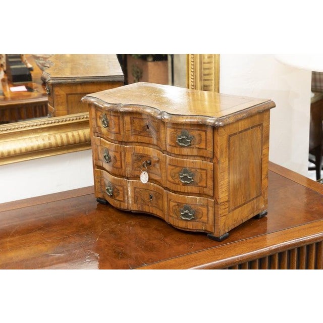 This is an exceptional Italian Baroque specimen chest crafted in richly figured walnut with beautifully matched burl...