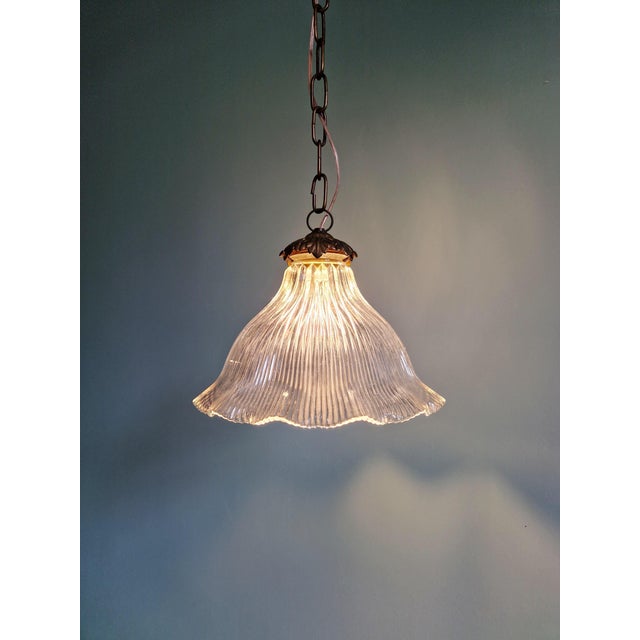 Holophane pendant light in clear fluted glass with a brass mount, 1930s. The shade is signed "holophane" inside the neck...