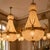 An impressive pair of 1960 French Louis XVI Rococo-style chandeliers, handcrafted in gilt bronze and designed on a grand...