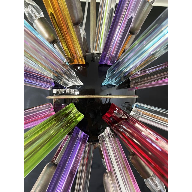 Sputnik chandelier surrounding 50 multicolored crystal glass 'triedri' prisms radiating from a center black metal nucleus....