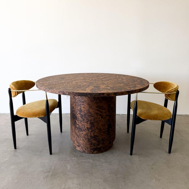 A striking 1970s Mid-Century Modern round dining table featuring richly figured burlwood veneer and a sculptural pedestal...