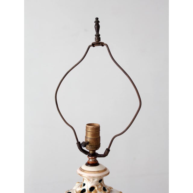 This vintage ceramic lamp draws from Italian Capodimonte and Rococo Revival design with its pierced urn form, hand painted...