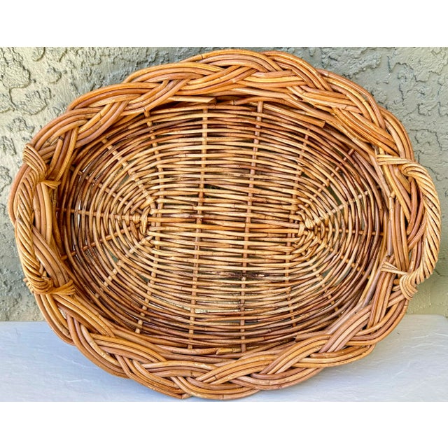 Vintage woven wicker basket with handles. Oval shaped. Larger size. Measures 17 1/2” long x 15” wide x 2 1/2” tall.