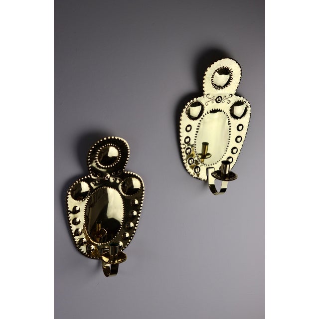 Made in Sweden A breath-taking mid-century duo of exquisite Swedish brass wall sconces, showcasing captivating hammered...