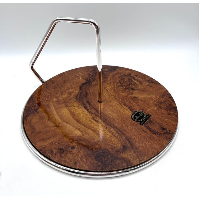 Elegant round serving tray from Sheratonn, crafted from silver-plated metal with a high-quality wood veneer top. The...