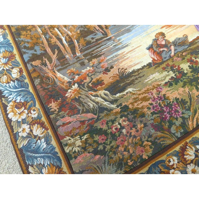 A scenic tapestry, depicting country landscape with flowing river and monument building in the background.