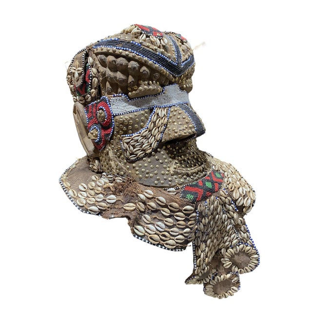 This impressive large vintage Kuba royal head mask from the Congo is crafted from wood, cloth, and raffia, adorned with...