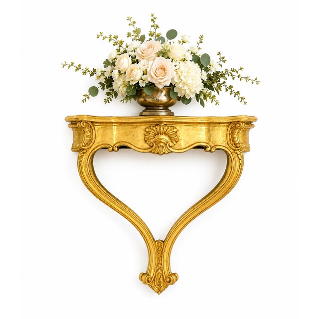 A beautifully carved Italian wall-mounted console, recently restored and refinished in a warm, luxurious gold finish. This...