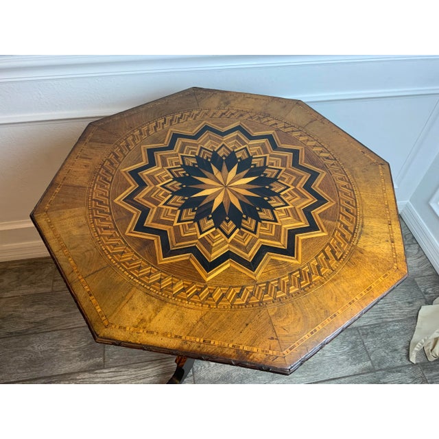 An exceptionally nice Walnut octagon marquetry tripod table. The Marquetry design on the top, base, and legs are...