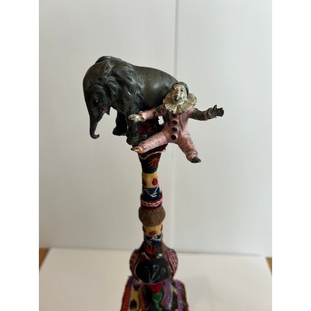 Delightfully whimsical found object sculpture with vintage elephant and clown on top of a rustic carved wood finial, with...