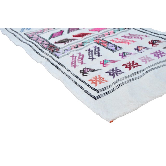 Handwoven Moroccan flat-weave wool rug, featuring an elegant rhythmic pattern of colorful animals, intricate Berber...