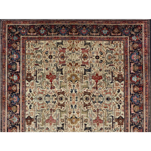 This antique Persian Tabriz rug features an all-over, sub-geometric unique design design rendered in multicolor, set upon...