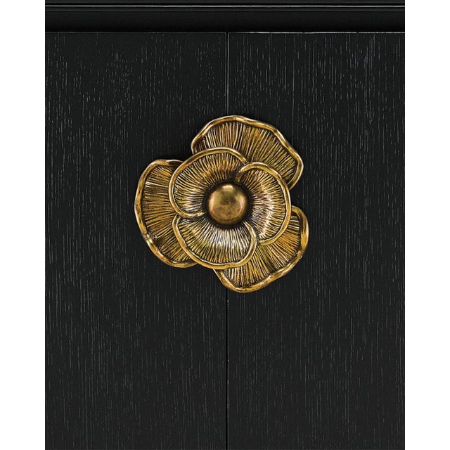 The impressively sized brass flower pull on the Briallen Black Demi-Lune Cabinet is a stunning ornamentation. Contrasting...