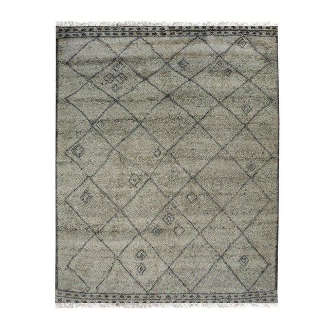 This gray wool rug features a hand knotted pile construction and originates from India. It serves as a durable floor...