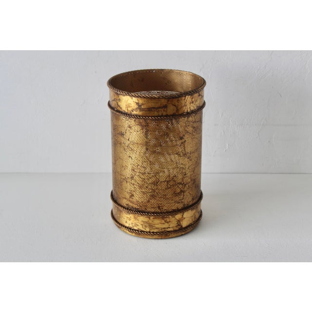 Elegant Mid-Century Regency paper basket made of gold-finish metal in the style of Li Puma. Perforated metal with a gold...