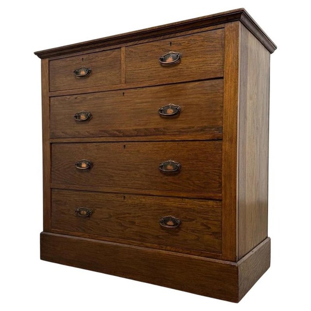 A handsome early 20th-century English Edwardian chest of drawers, finely crafted from oak and distinguished by its...