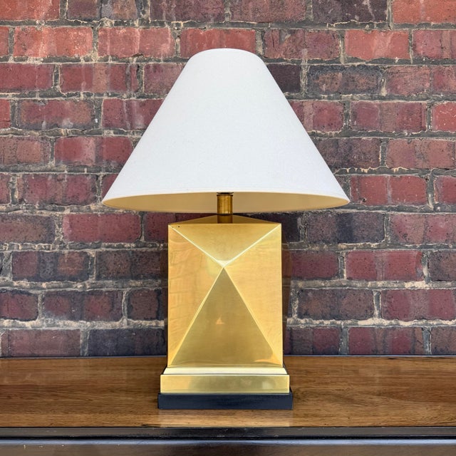 This geometric brass lamp is architecturally stunning and in working order. The top corners of the lamp have a little play...