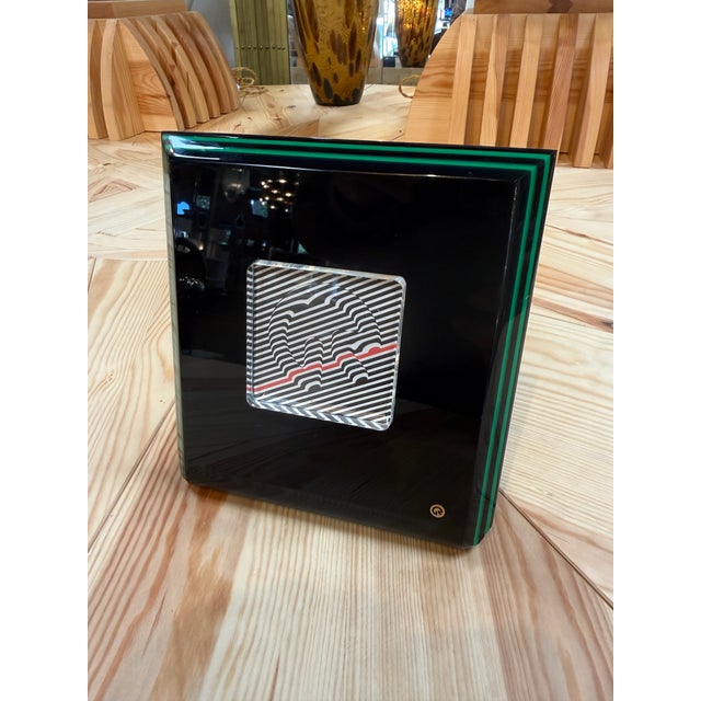 A square picture frame by Rede Guzzini with a glossy black face and layered green edges. Its central window features a...