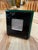 A square picture frame by Rede Guzzini with a glossy black face and layered green edges. Its central window features a...