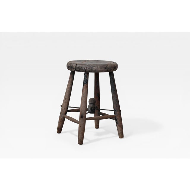 Antique French Provincial workshop stool, circa 1920s. Thick-cut round wooden seat supported by four splayed legs and an...