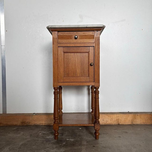 This elegant antique bedside table made of solid oak combines classic craftsmanship with practical functionality. The...