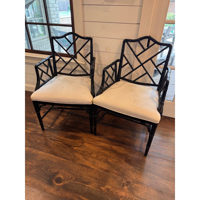 Pair of upholstered and faux bamboo black painted Chinese Chippendale style armchairs, probably Baker, no labels or tags.