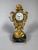 A Louis XV style Chinese clock, early 19th century. It depicts a Chinese figure seated cross-legged supporting a rocaille...