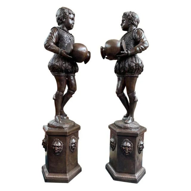 Stunning pair of large bronze statues in the form of a pair of elizabethan page boys. Each boy holds the urn from where...