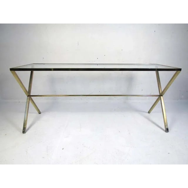Vintage mid-century style console table with a brass colored frame and a glass insert serving as the tabletop. Interesting...