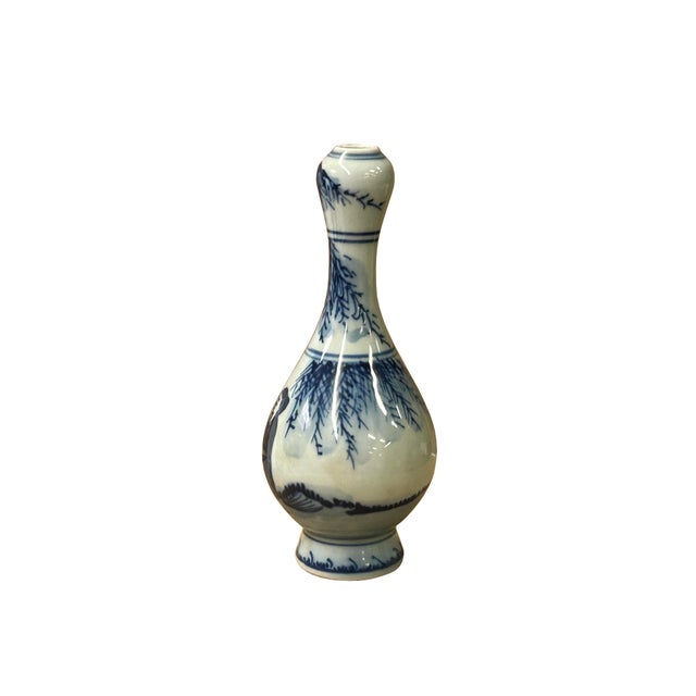 This delicate, miniature porcelain vase features a classic blue-and-white underglaze motif, showcasing a graceful pear-...