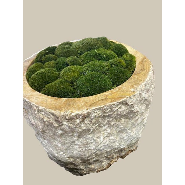 A large planter hand-carved from a single piece of raw onyx, the rugged natural outer edge left intact against a smoothly...