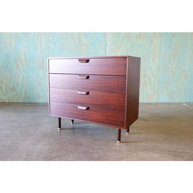 A chest of drawers designed by Harvey Probber c. 1950s. Rich mahogany cases with even drawers floating above cylindrical...