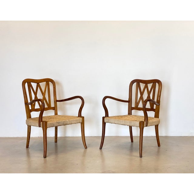 Pair of 1940s armchairs, oak wood structure and straw seat, the two armchairs differ by two cm. in the height of the...