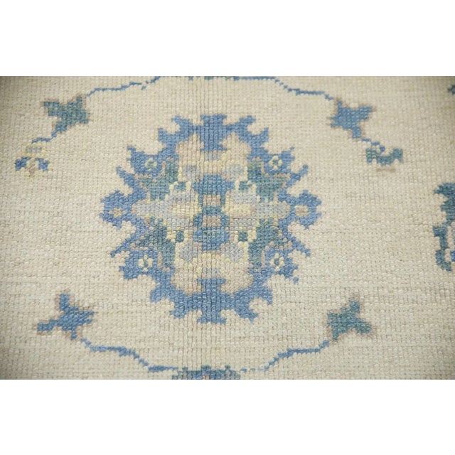 This modern Turkish Oushak rug is a stunning piece of art that has been handwoven using traditional techniques by skilled...