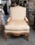 This is one of an elegant identical pair of French Louis XV-style arm chairs crafted in richly figured walnut with...