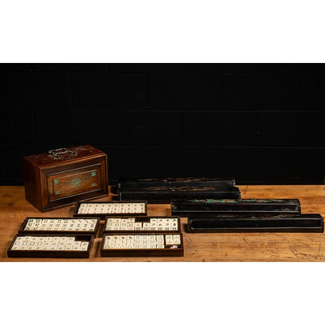 Antique Chinese-produced Mahjong game set. The tiles have a bamboo base with a top made from bone that has embossed and...