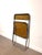 iconic folding chair in the manner of Giancarlo Piretti,. The chair features a smoked amber transparent polycarbonate seat...