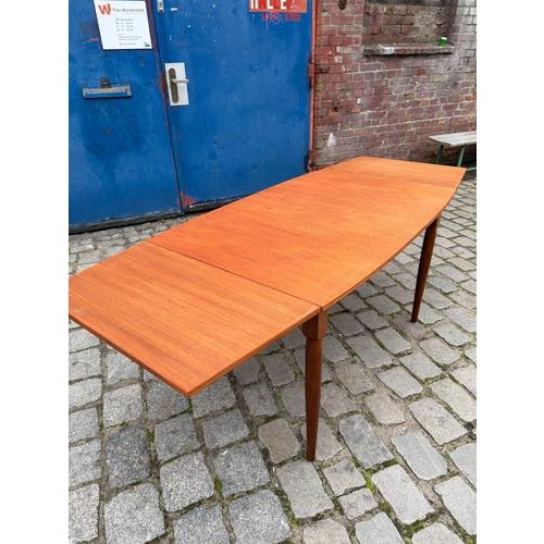 This restored extendable table, crafted from warm teak and solid oak, impresses with its masterful lines and striking...