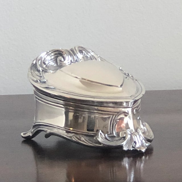 Offering a lovely antique silver plated jewelry box from the early 20th century. This gorgeous box features an ornate Art...