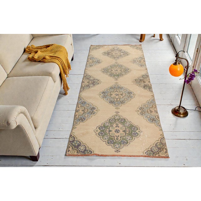 This is a vintage Turkish Oushak rug from the Mid 20th Century. The piece was hand-knotted.