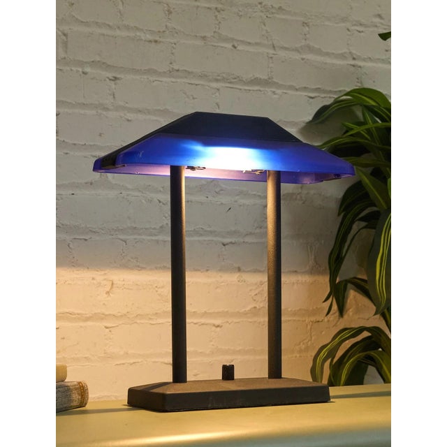 A graphic vintage desk lamp with a distinctly postmodern profile, pairing a vivid cobalt blue shade with a matte black...